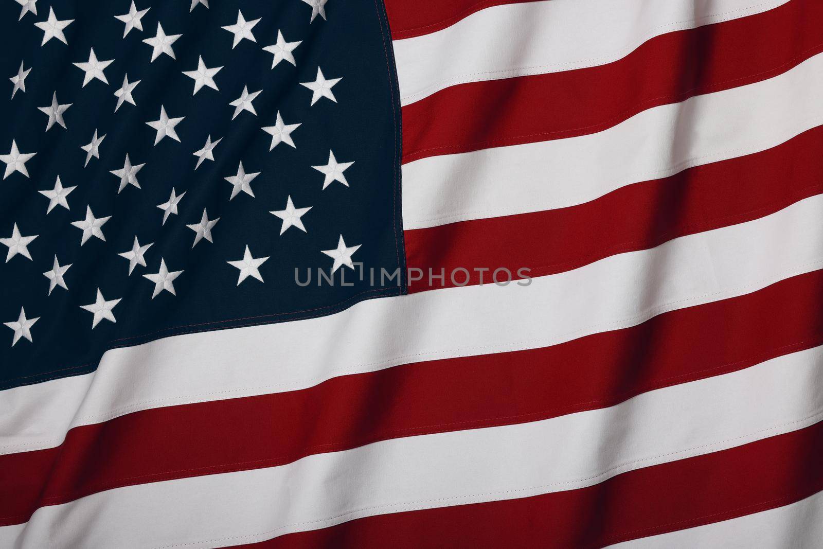 Close up heavy cotton canvas US national flag background, symbol of American patriotism, elevated high angle view, directly above