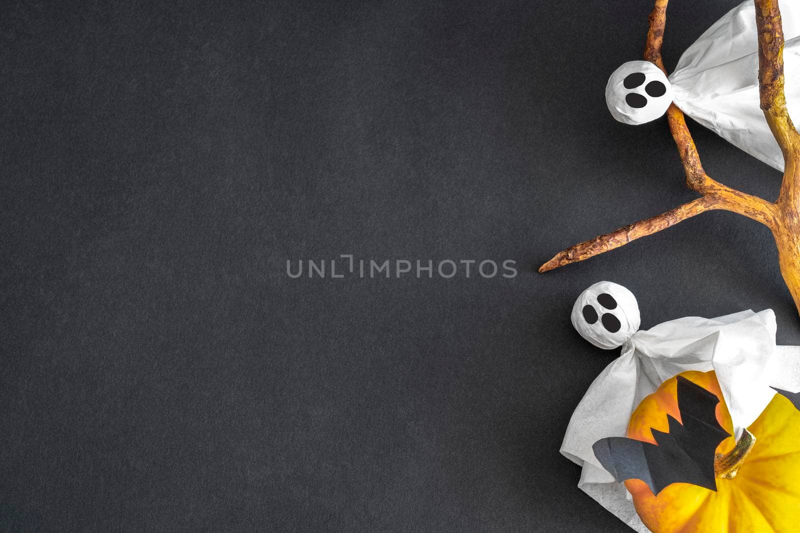 Halloween symbols - two ghosts with pumpkin on black background. Copy space.