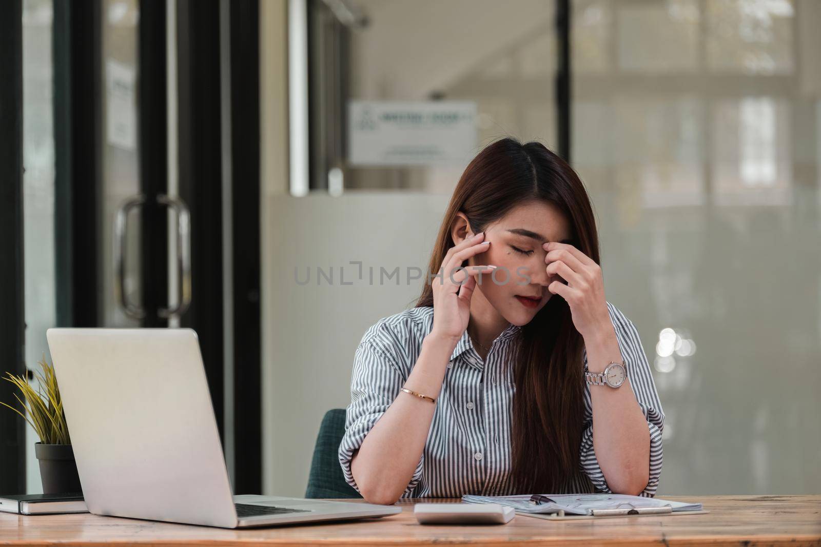 Stressed young woman sitting at desk working from home office, businesswoman headache while having a problem at work in office.