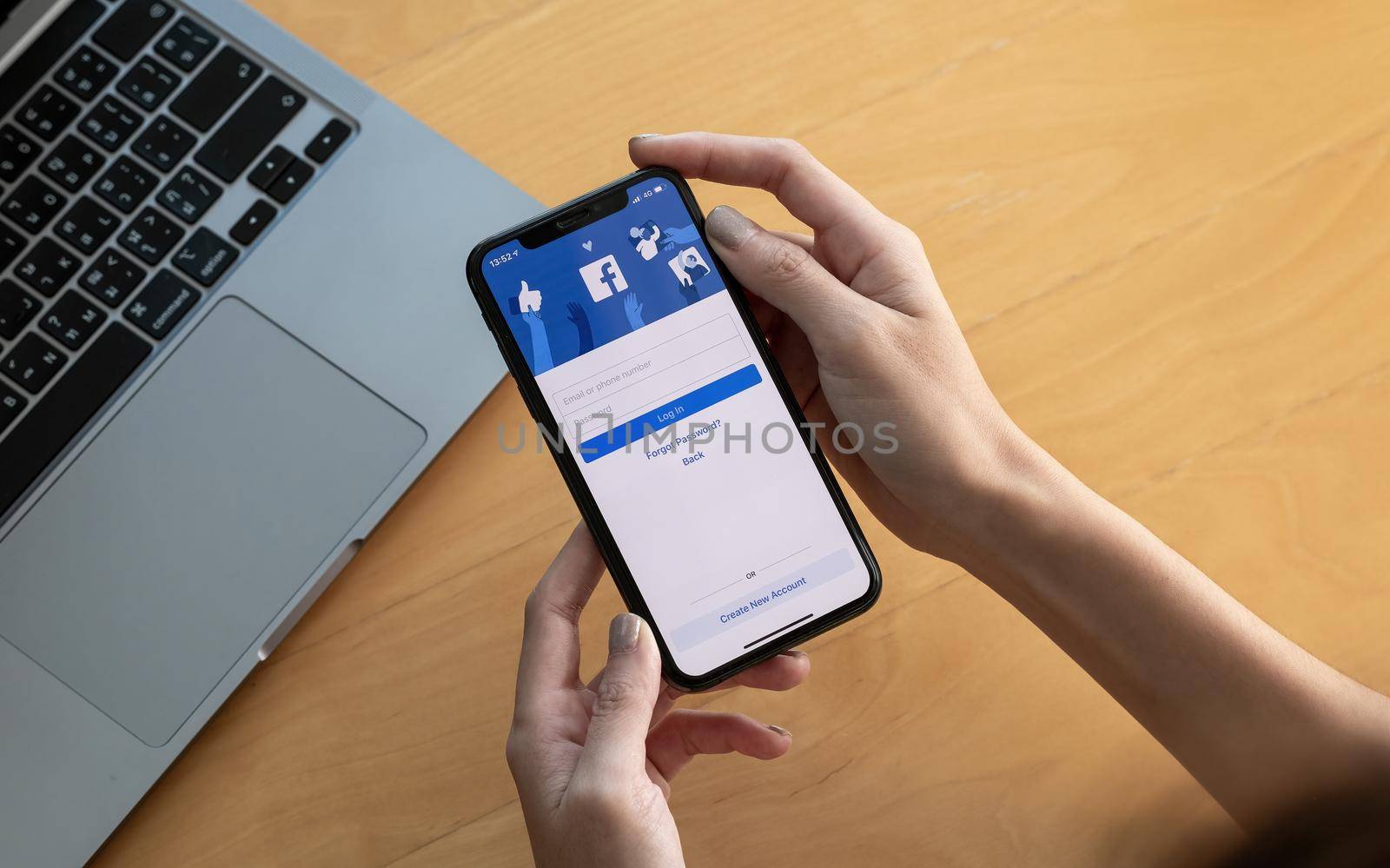 CHIANG MAI, THAILAND - OCT 03, 2018: Facebook social media app logo on log-in, sign-up registration page on mobile app screen on iPhone X in person's hand working on e-commerce shopping business