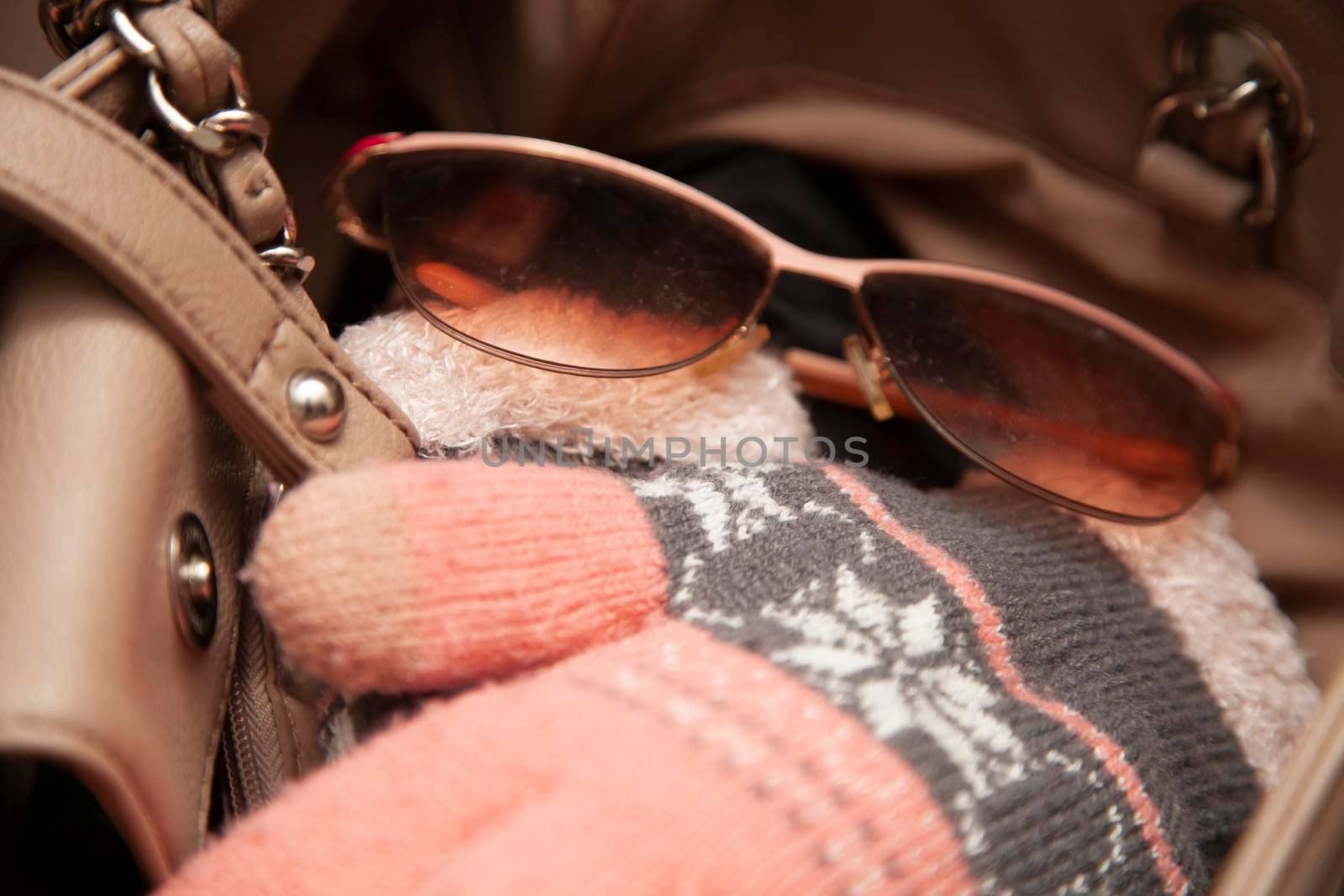 Shades and pink gloves in a beige purse