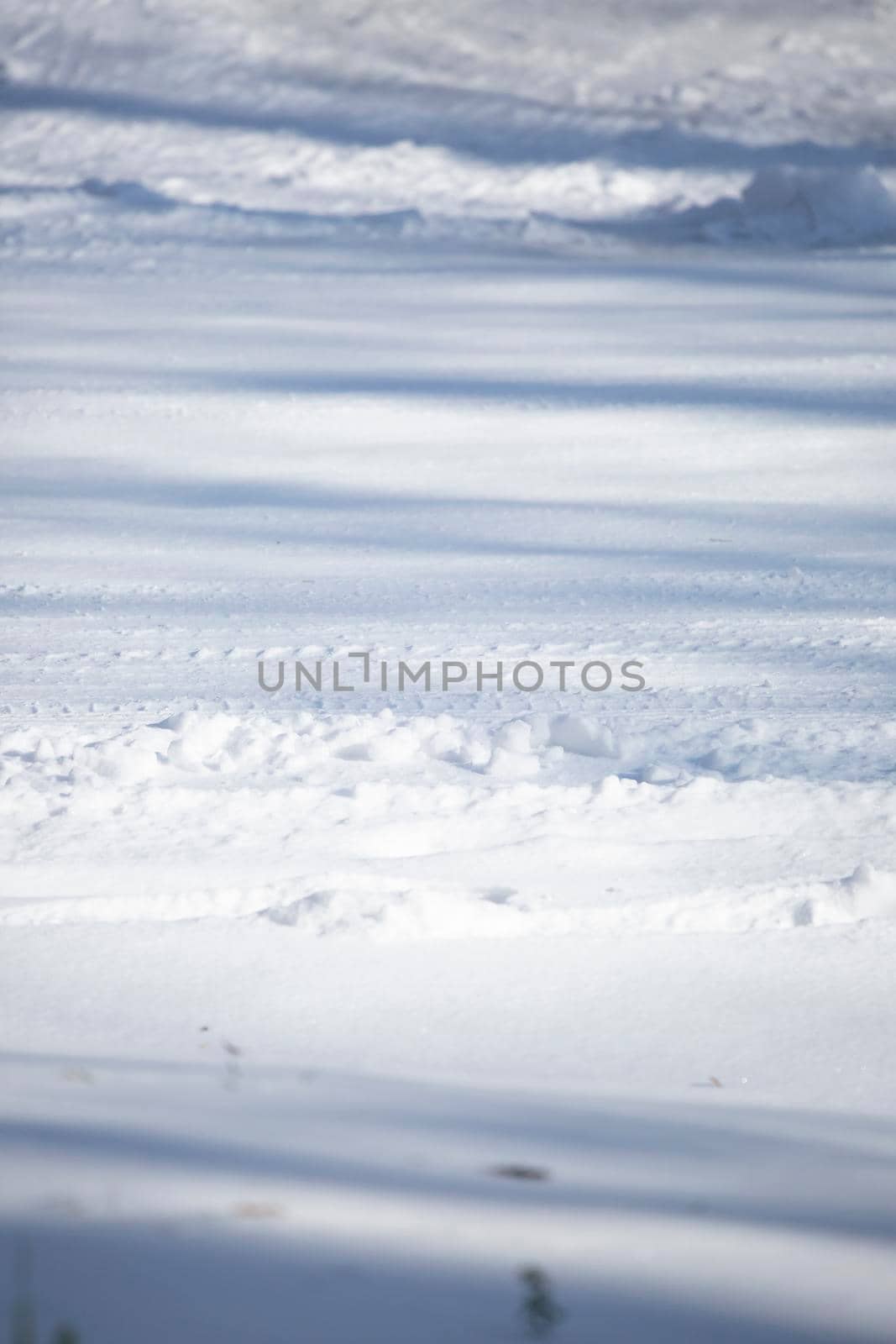 Shallow tire tracks on a dangerous snow-covered road
