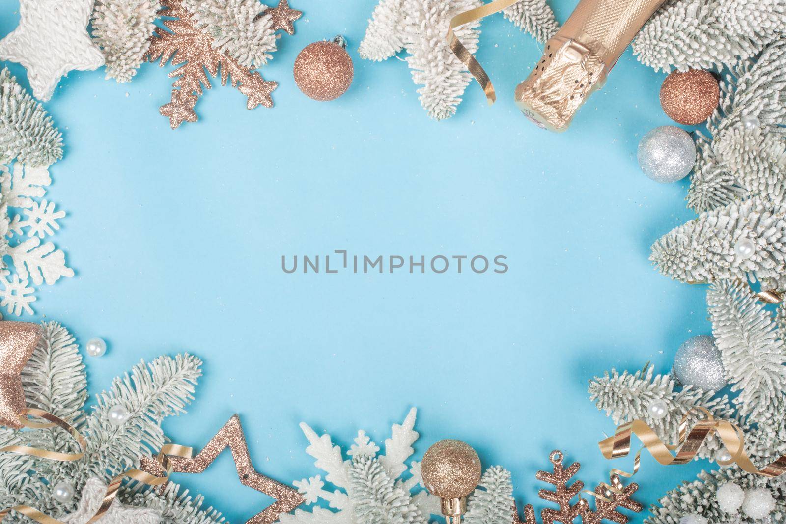 Frosted fir tree twigs and Christmas decorative bauble balls on blue background with copy space for text template flat lay top view design