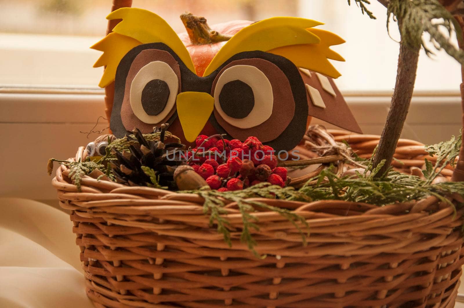 owl made of paper in a basket with rowan berries. Autumn