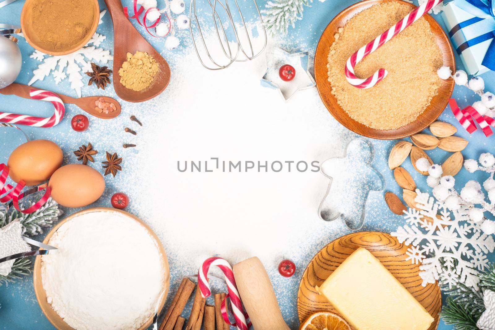 Christmas gingerbread cookies cooking background flat lay top view template with copy space for text. Baking utensils, spices and food ingredients on blue background