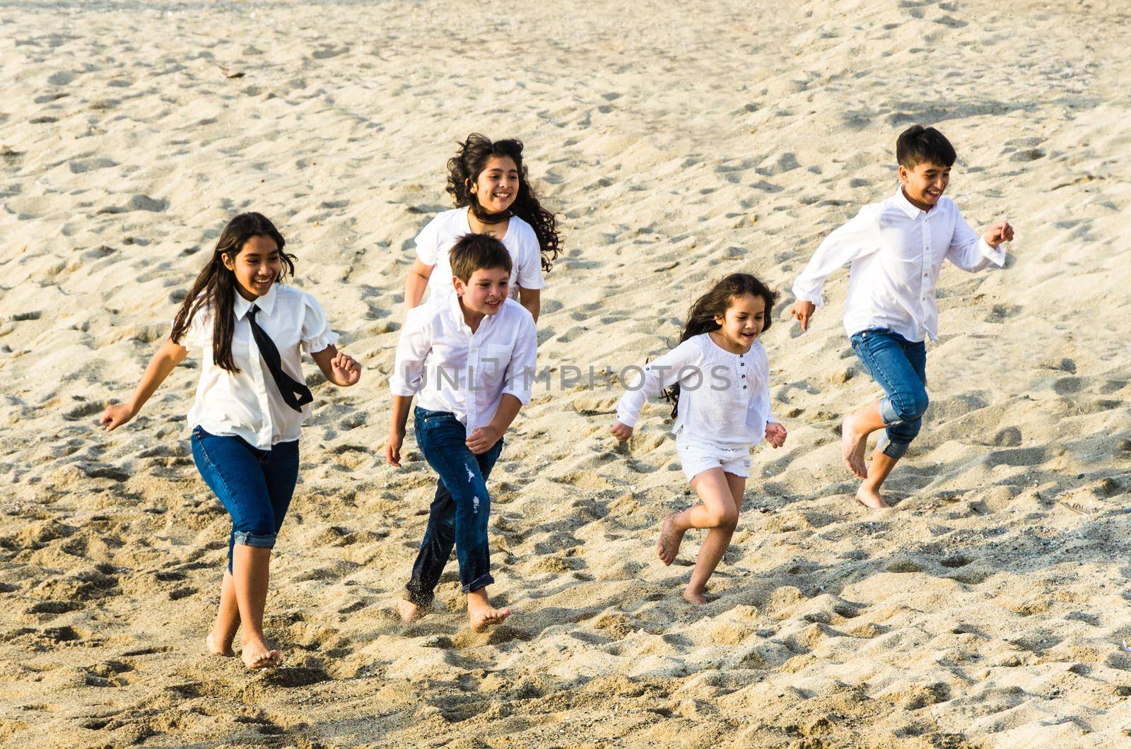 Children running along the shore of the beach by Peruphotoart