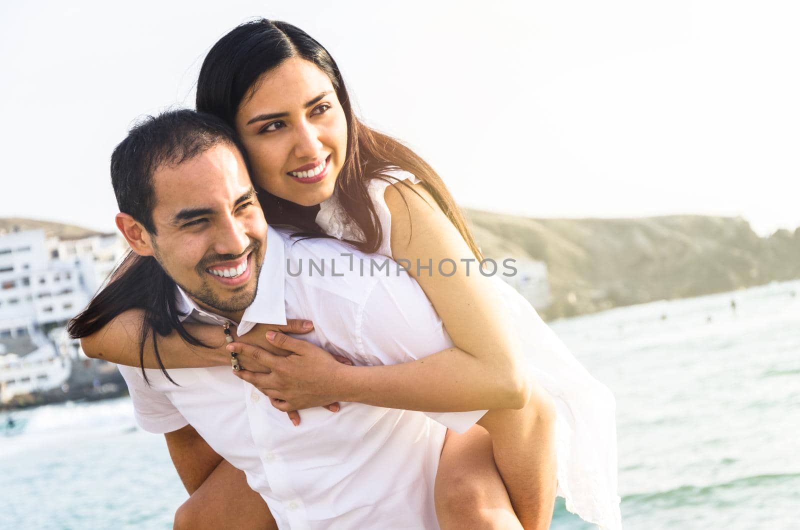 Young man carrying his girlfriend in his arms by Peruphotoart