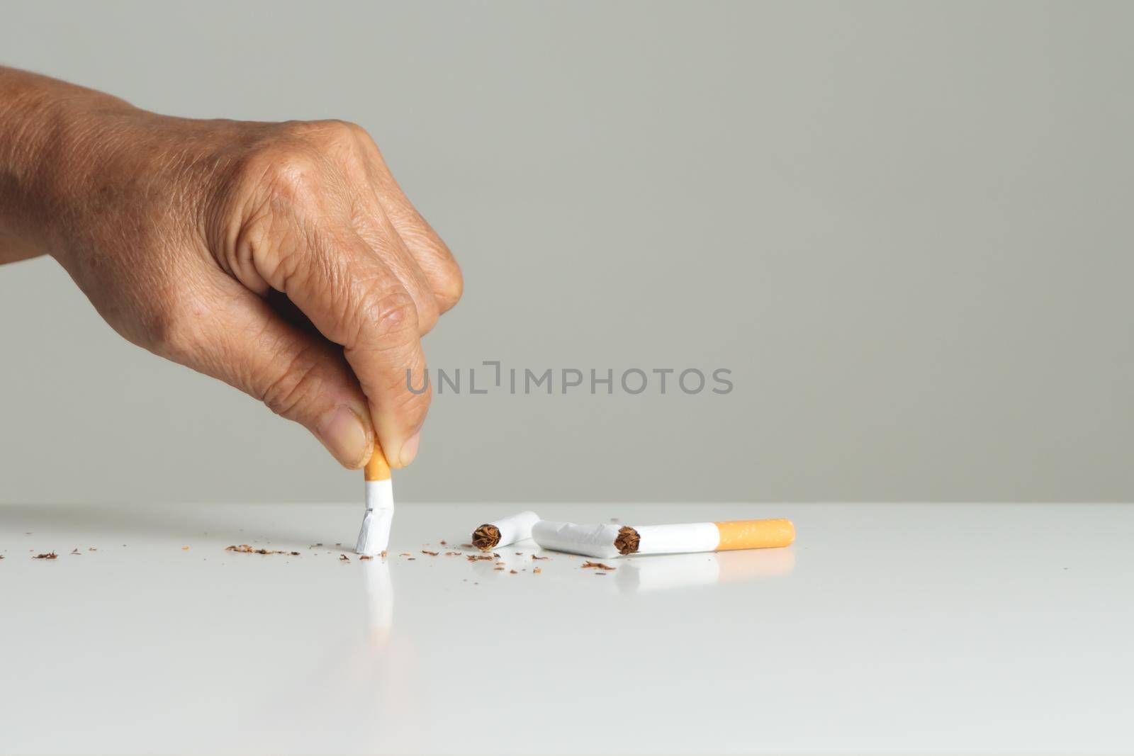 Quit smoking, no tobacco day, mother hands breaking the cigarette by psodaz