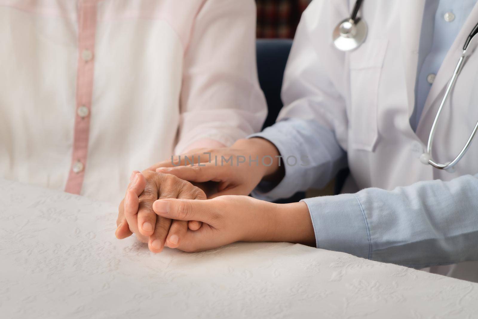 Doctor hands together holding senior woman patient