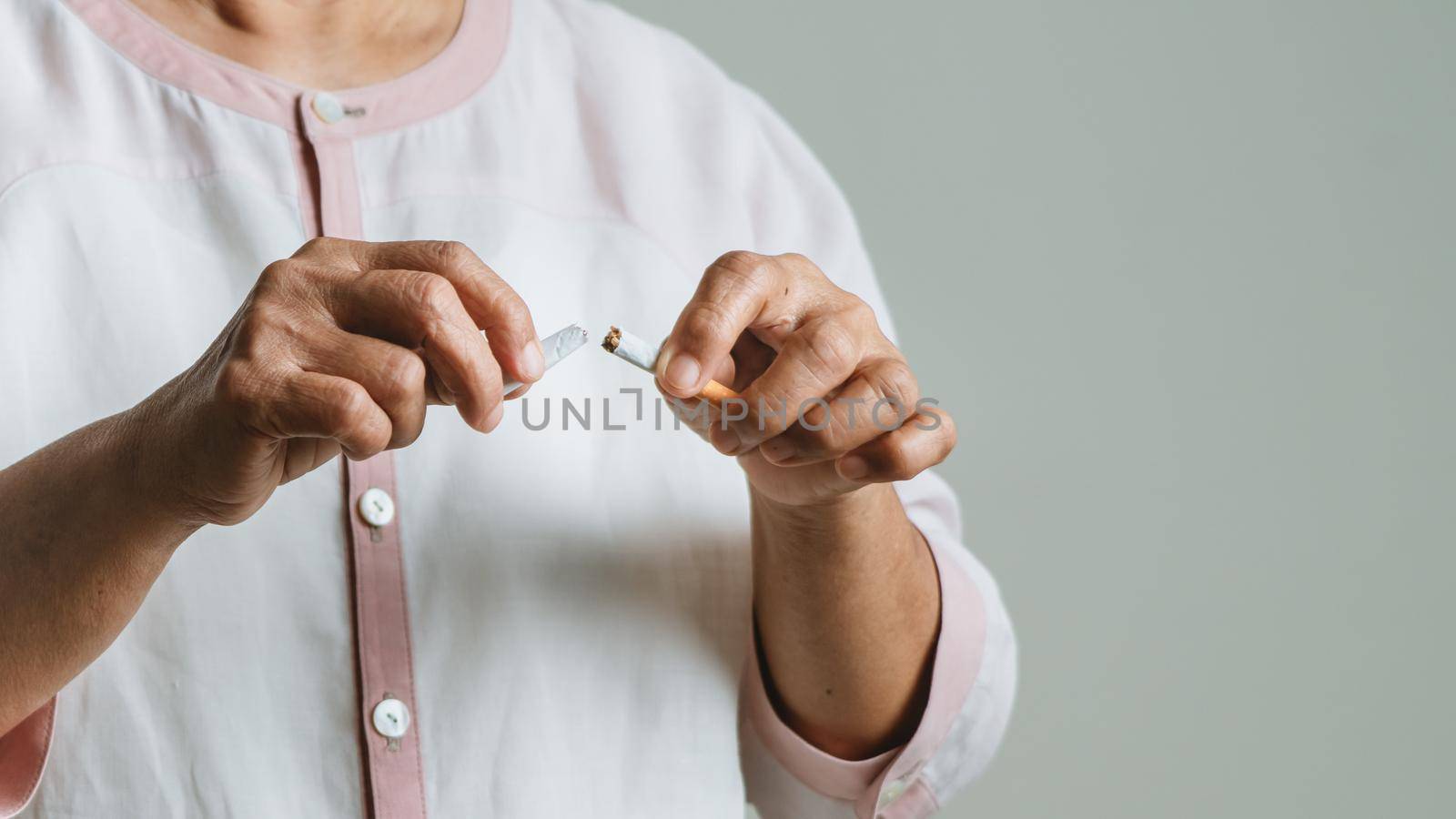 Quit smoking, no tobacco day, mother hands breaking the cigarette