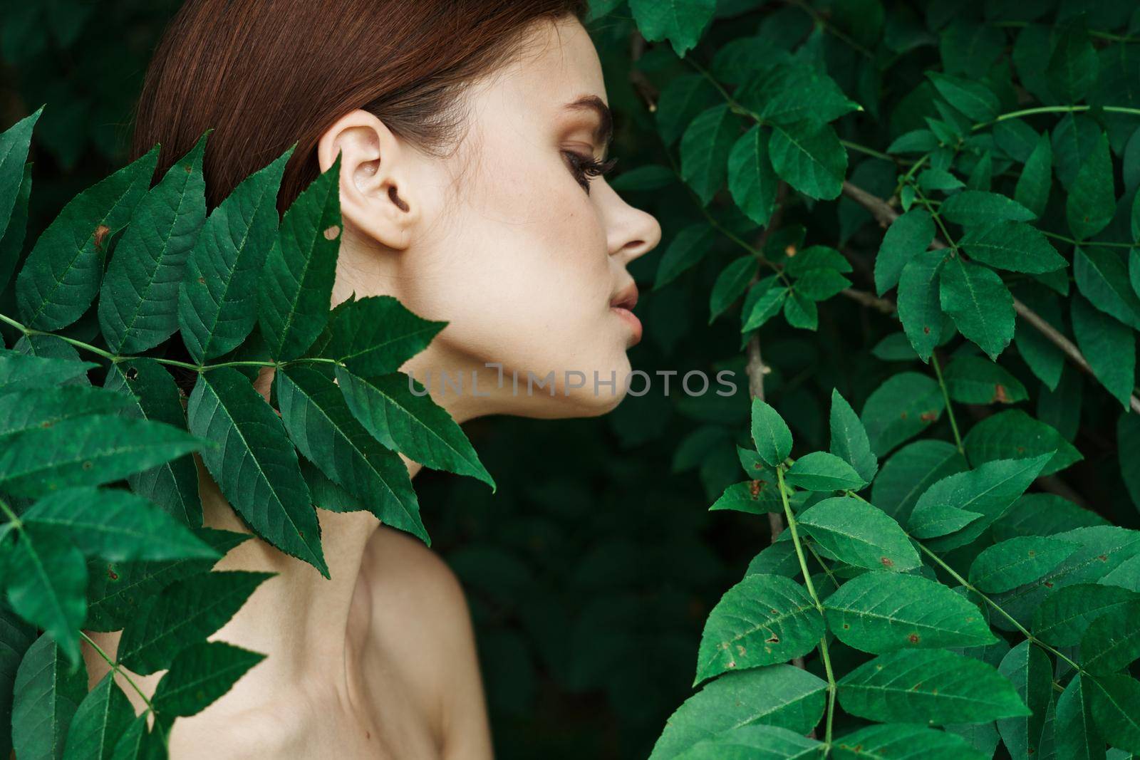 smiling woman skin care bare shoulders green leaves nature model. High quality photo