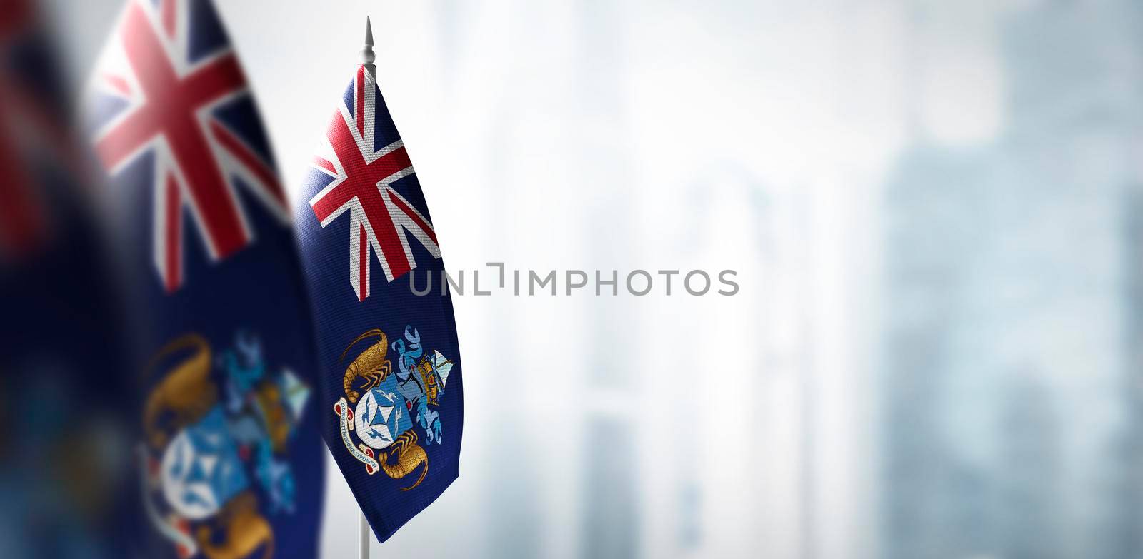 Small flags of Tristan da Cunha on a blurry background of the city by butenkow