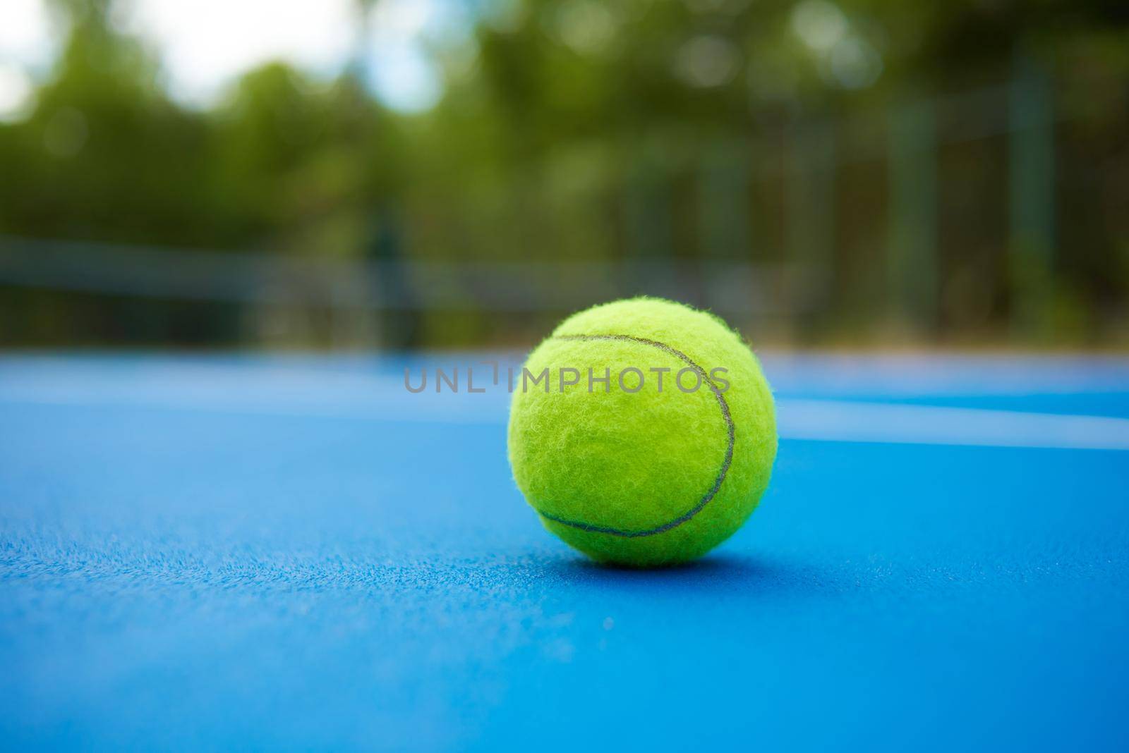 Yellow ball on blue tennis court background. by SerhiiBobyk