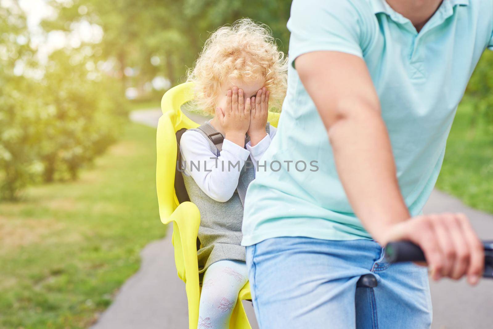 Scared baby girl in a bike seat on a bicycle by SerhiiBobyk