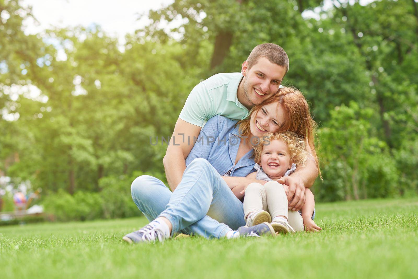 Happy young family relaxing at the park by SerhiiBobyk
