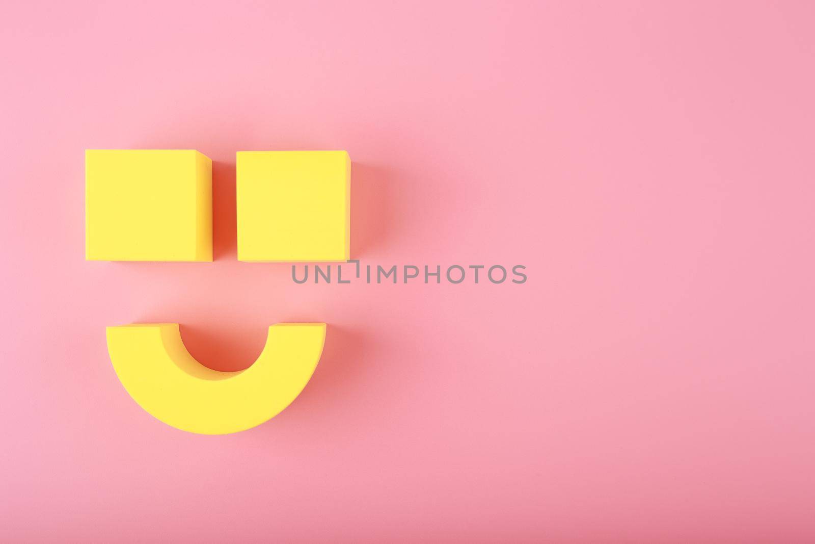 Creative flat lay with yellow happy smile symbol made of figures on pink background with copy space. Concept of Smile day, emotions, emoji or mental health