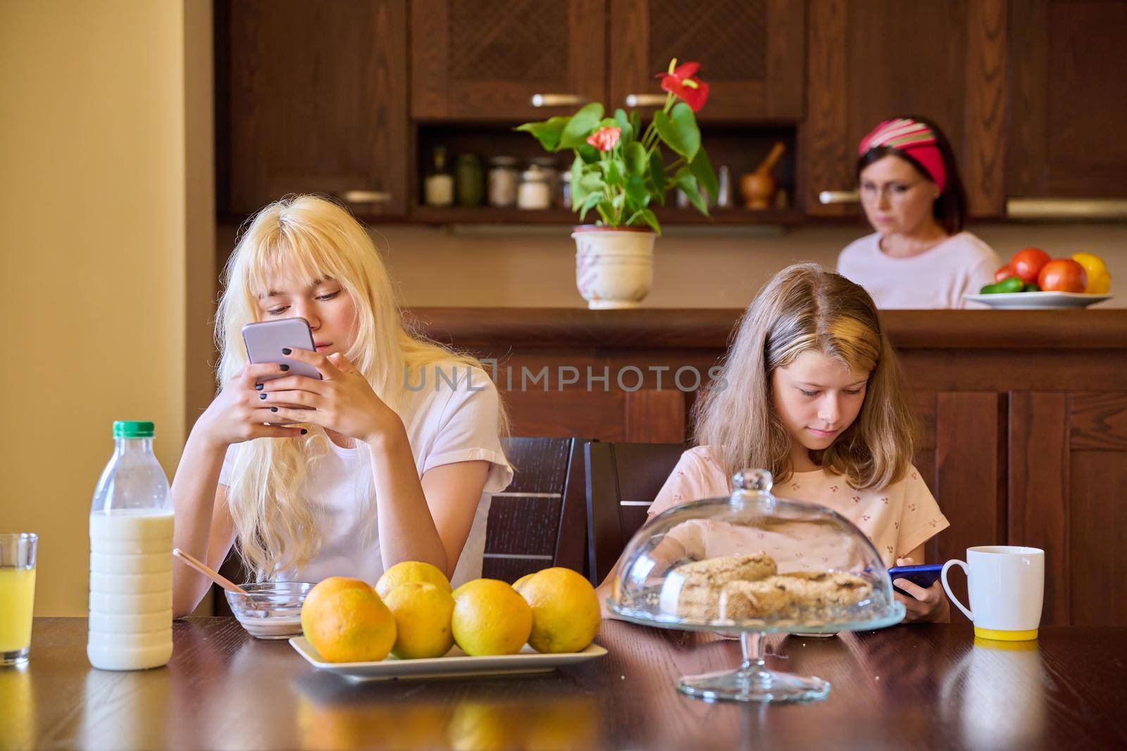 Family, girls, children eating at the table in the kitchen by VH-studio