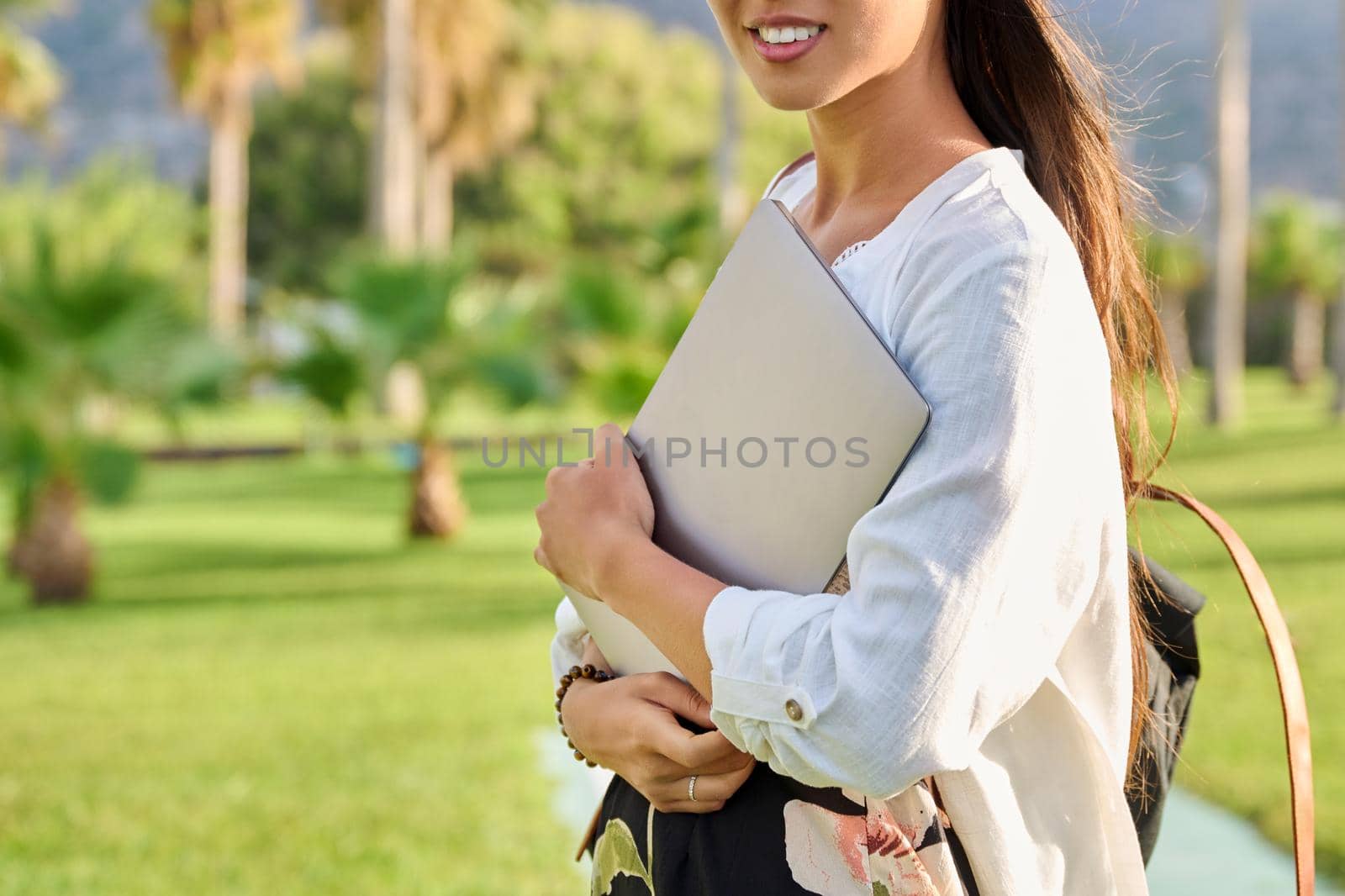 Outdoor portrait of young woman with laptop and backpack. by VH-studio