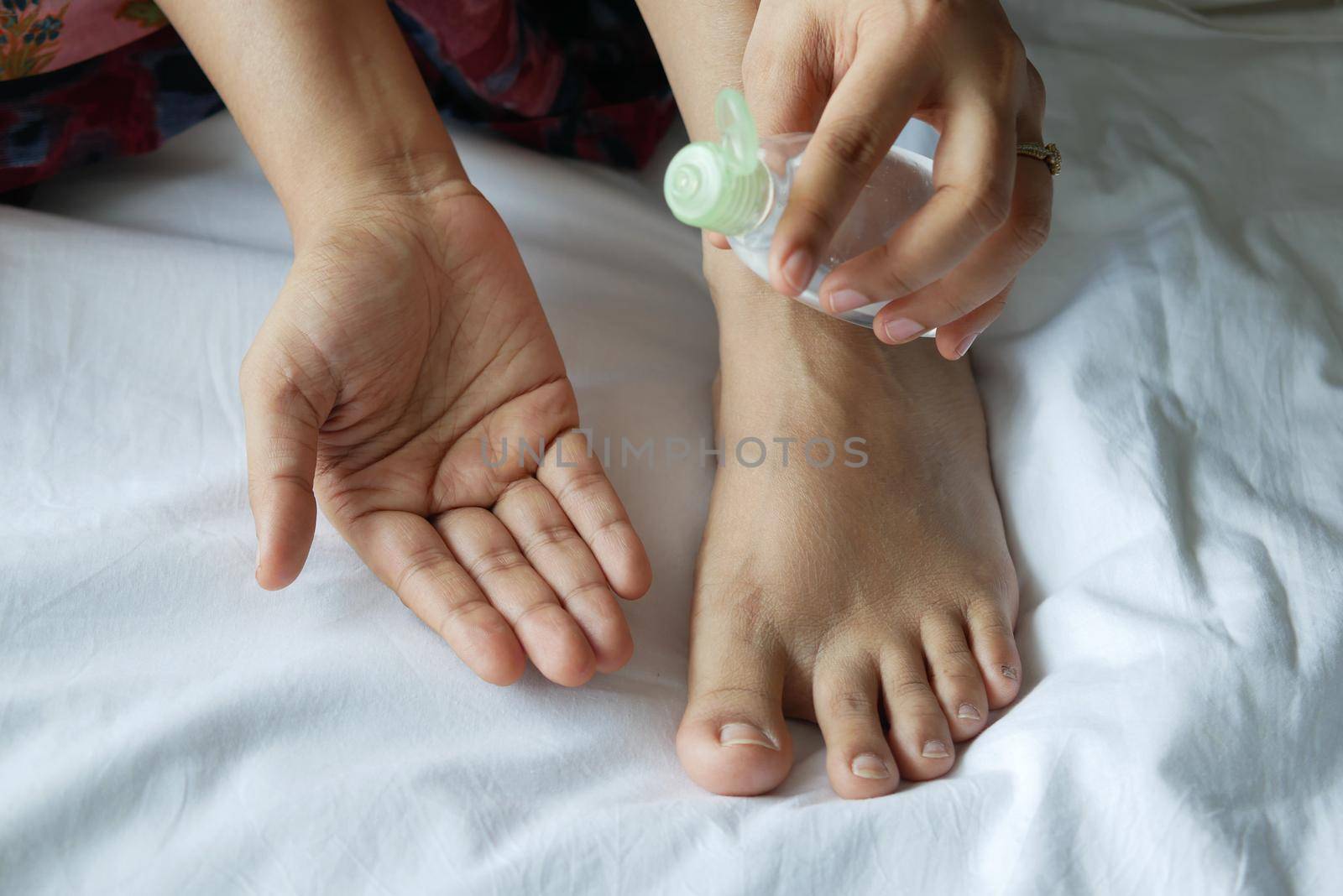 women apply oil on feet on bed