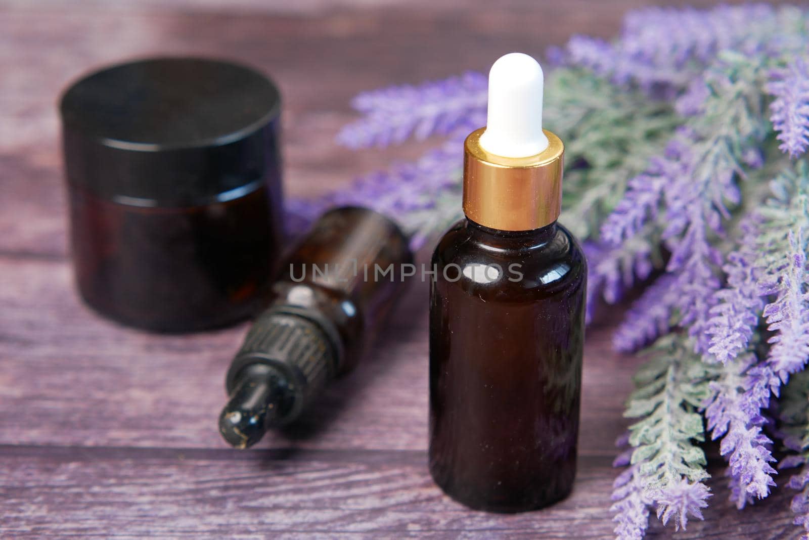 Essential lavender oil and flowers on table with copy space .