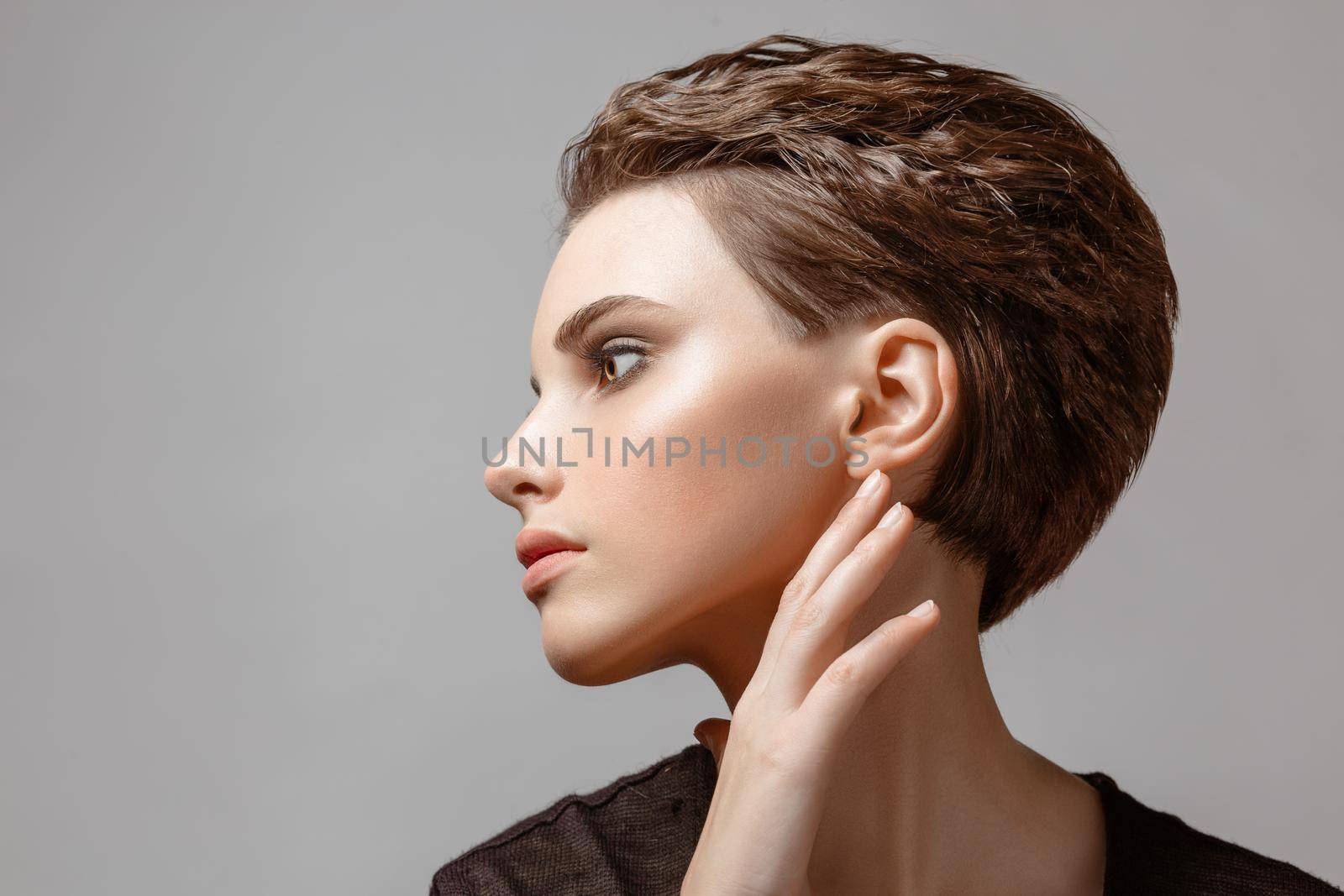 Young woman posing in studio on gray background close-up