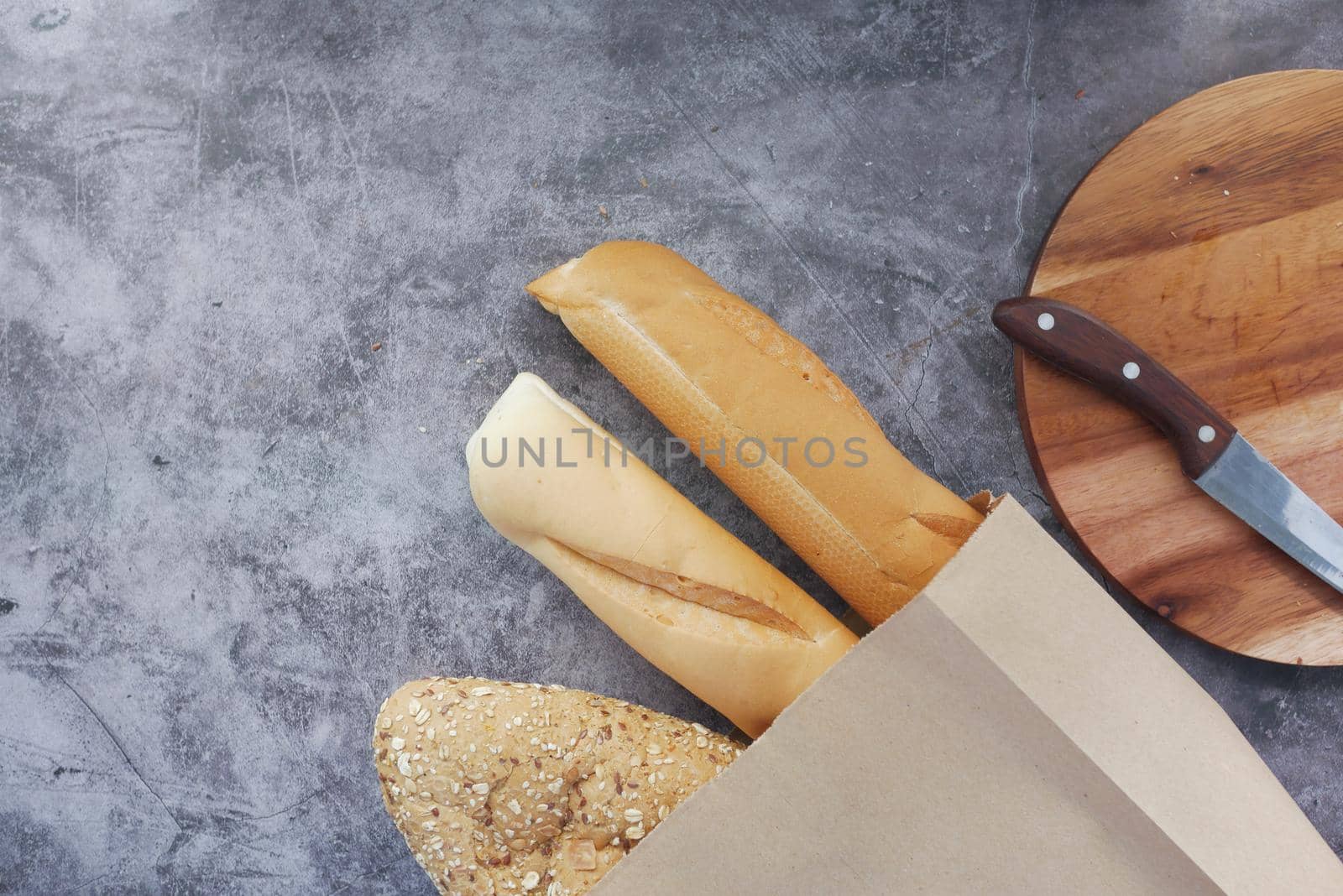 top view of baked bread in a paper bag on black background .