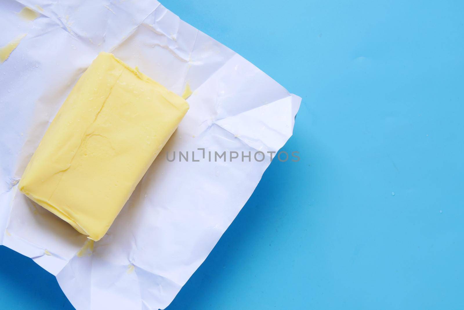 slice of a butter on a paper on table .
