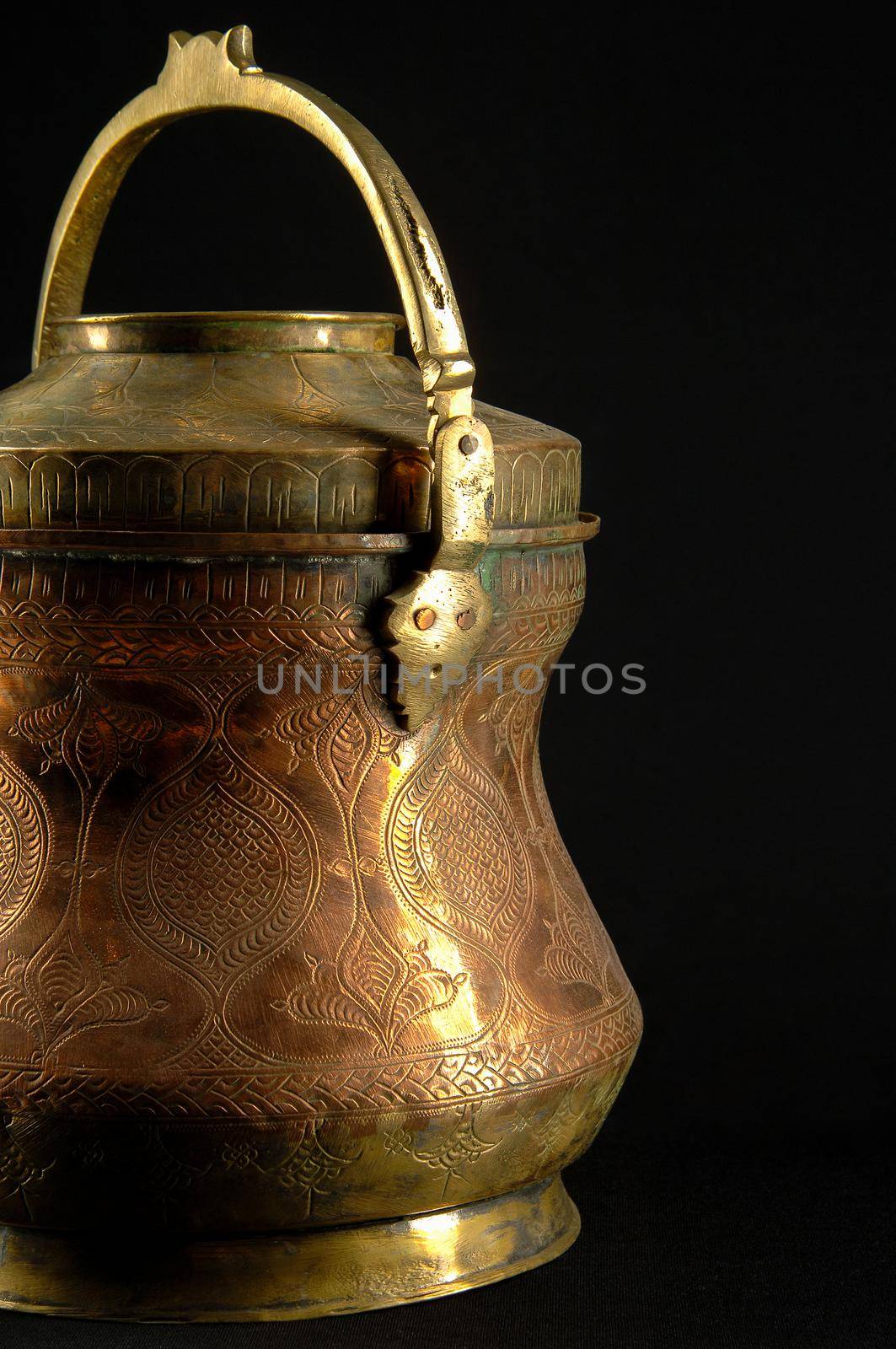 Ancient metal bowl on dark background. Antique bronze tableware