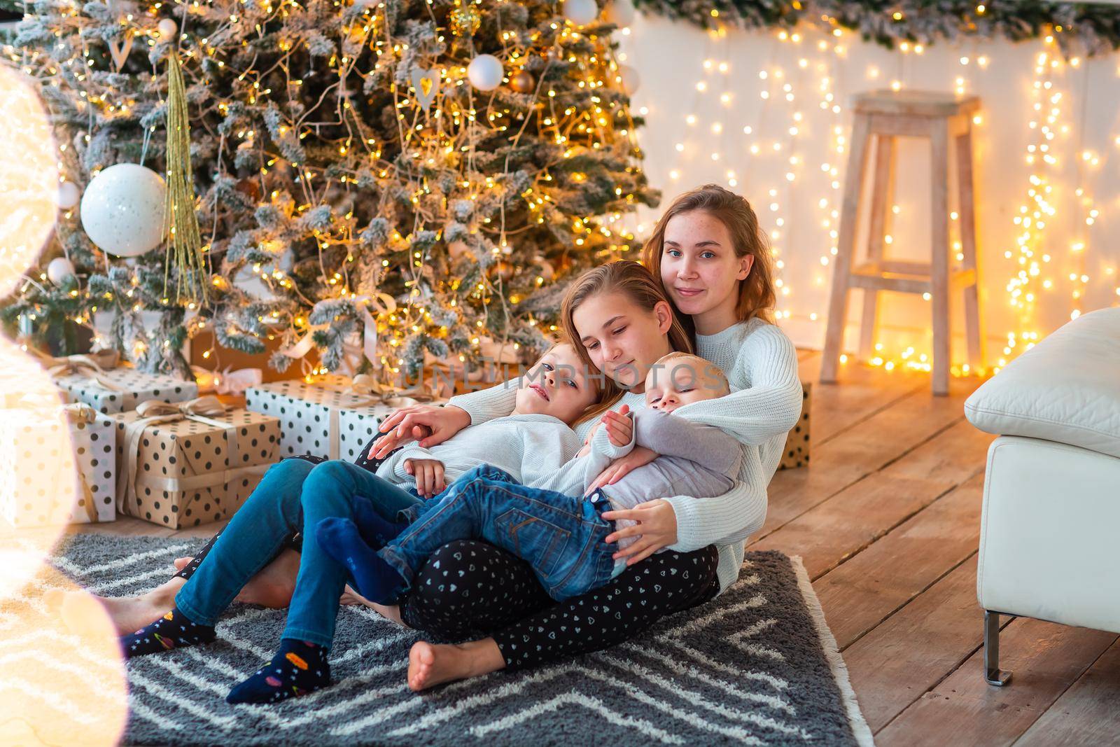 Happy kids sibilings near the Christmas tree with the present boxes. Christmas morning, christmas mood concept