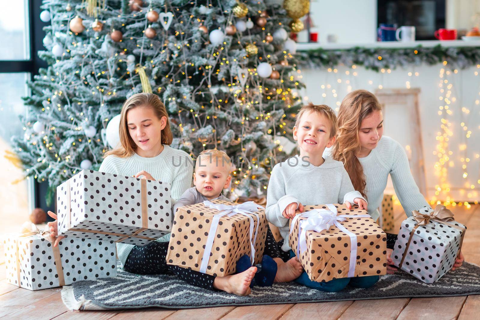 Happy kids sibilings near the Christmas tree with the present boxes. Christmas morning, christmas mood concept