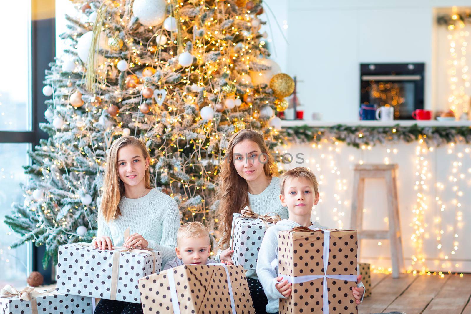 Happy kids sibilings near the Christmas tree with the present boxes. Christmas morning, christmas mood concept