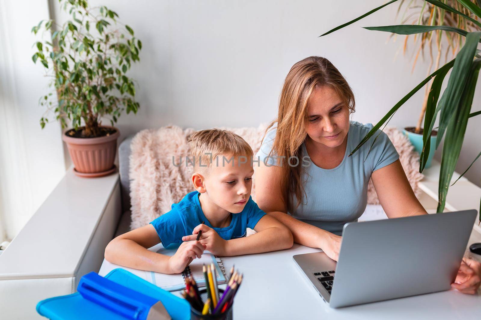 Mother with kid trying to work from home during quarantine. Stay at home, work from home concept during coronavirus pandemic