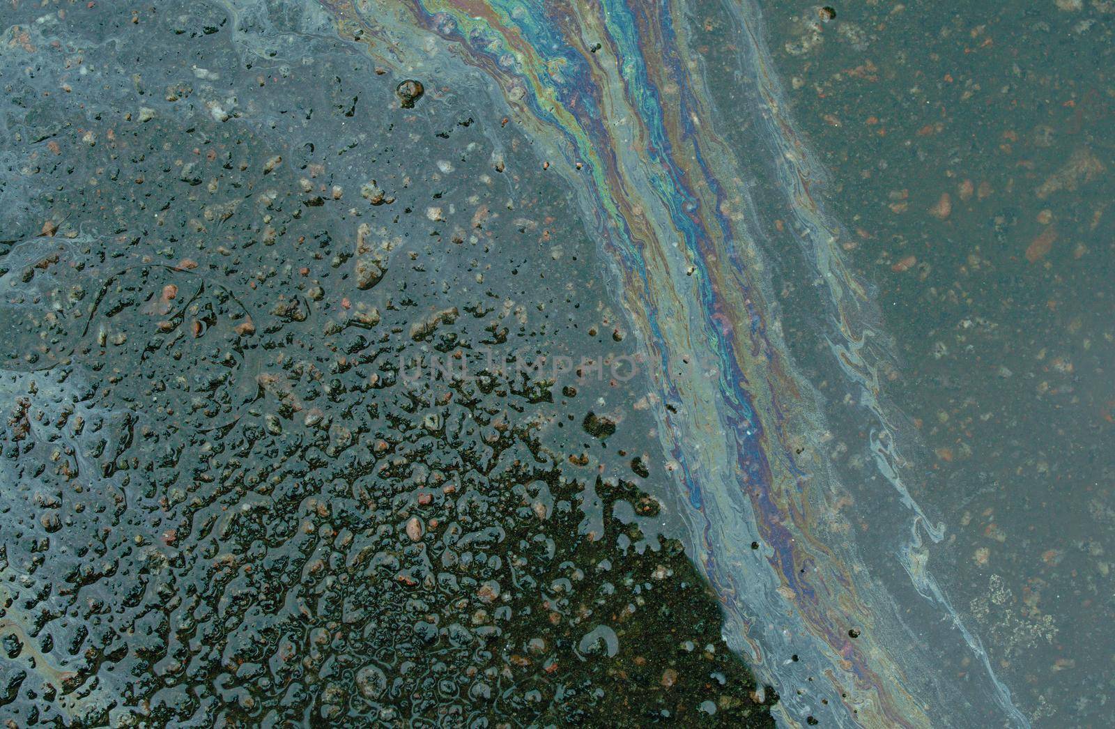 Abstract background from motor oil, gas or petrol spilled on asphalt