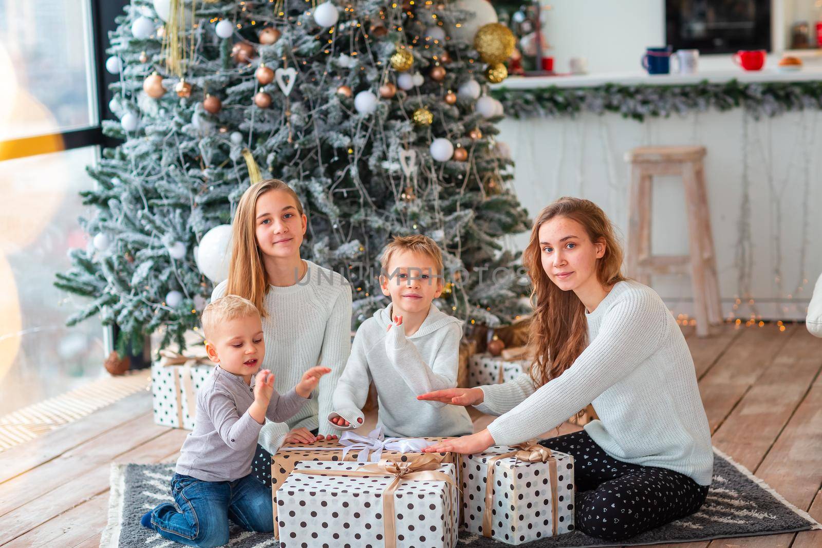 Happy kids sibilings near the Christmas tree with the present boxes. Christmas morning, christmas mood concept