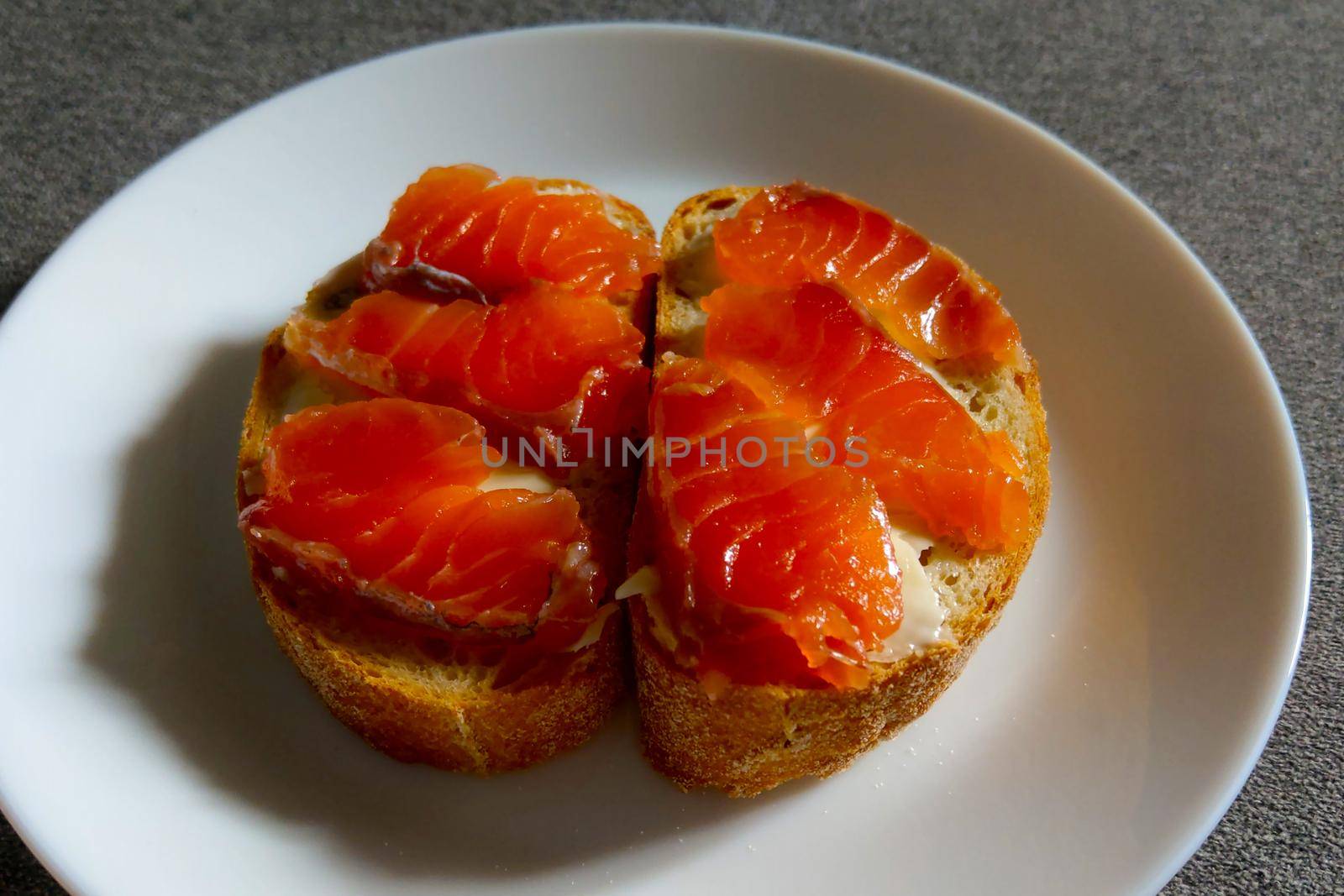 Sandwich on a white plate of red fish