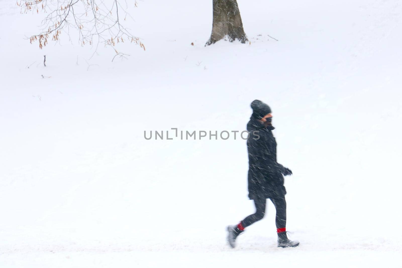 Out of focus, blurry background, a person goes on a snowy winter day. Bad weather. by kip02kas