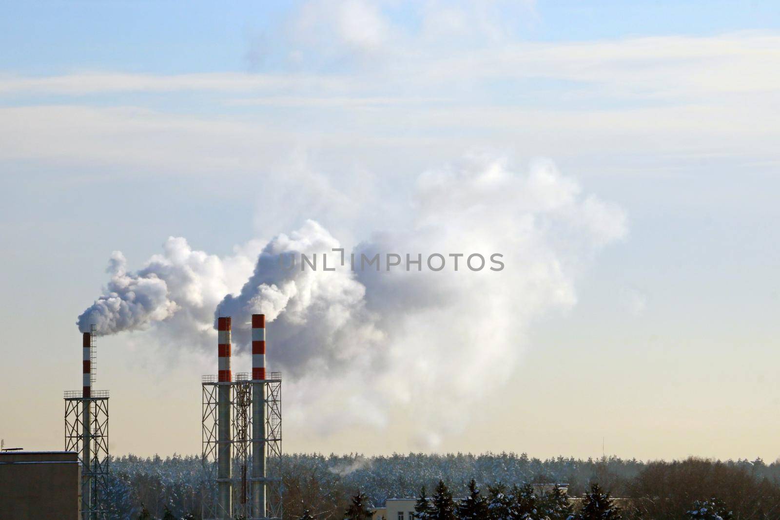 From the chimney there is smoke in winter against the sky