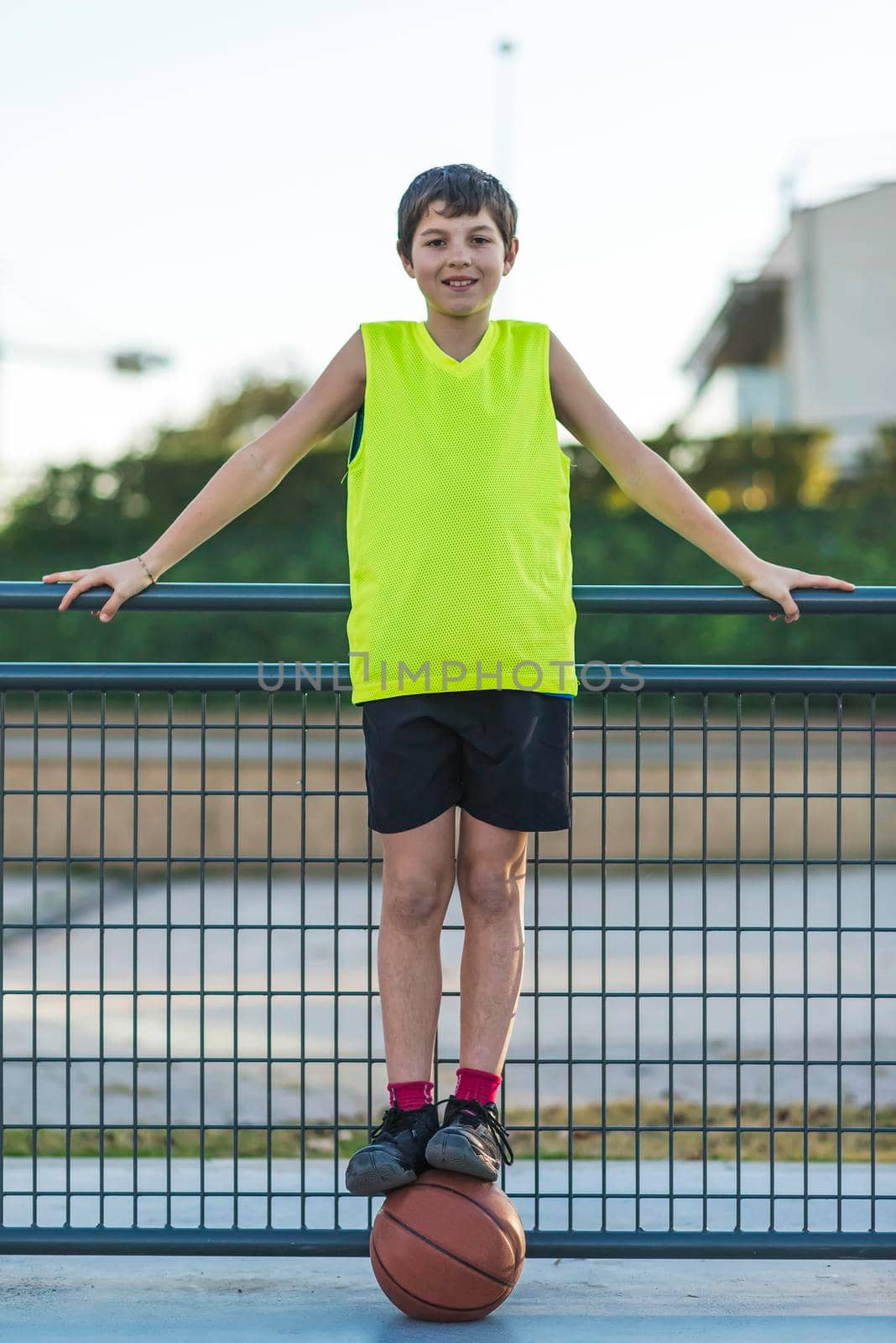 Portrait of young teen wearing a yellow basketball sleeveless smiling