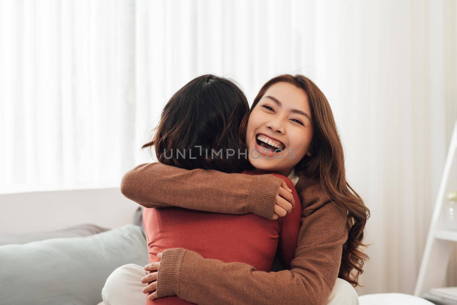 Young woman hugging her friend at home.