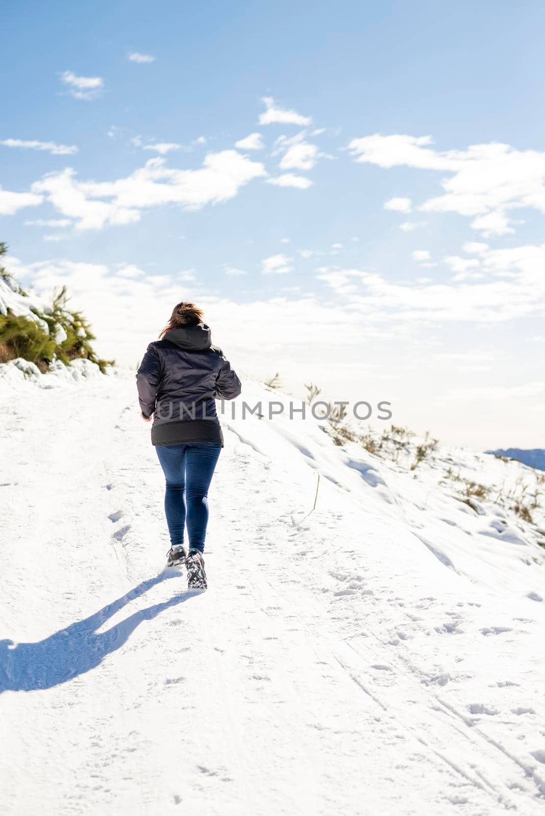 A Young traveler woman jogging on snowed mountain