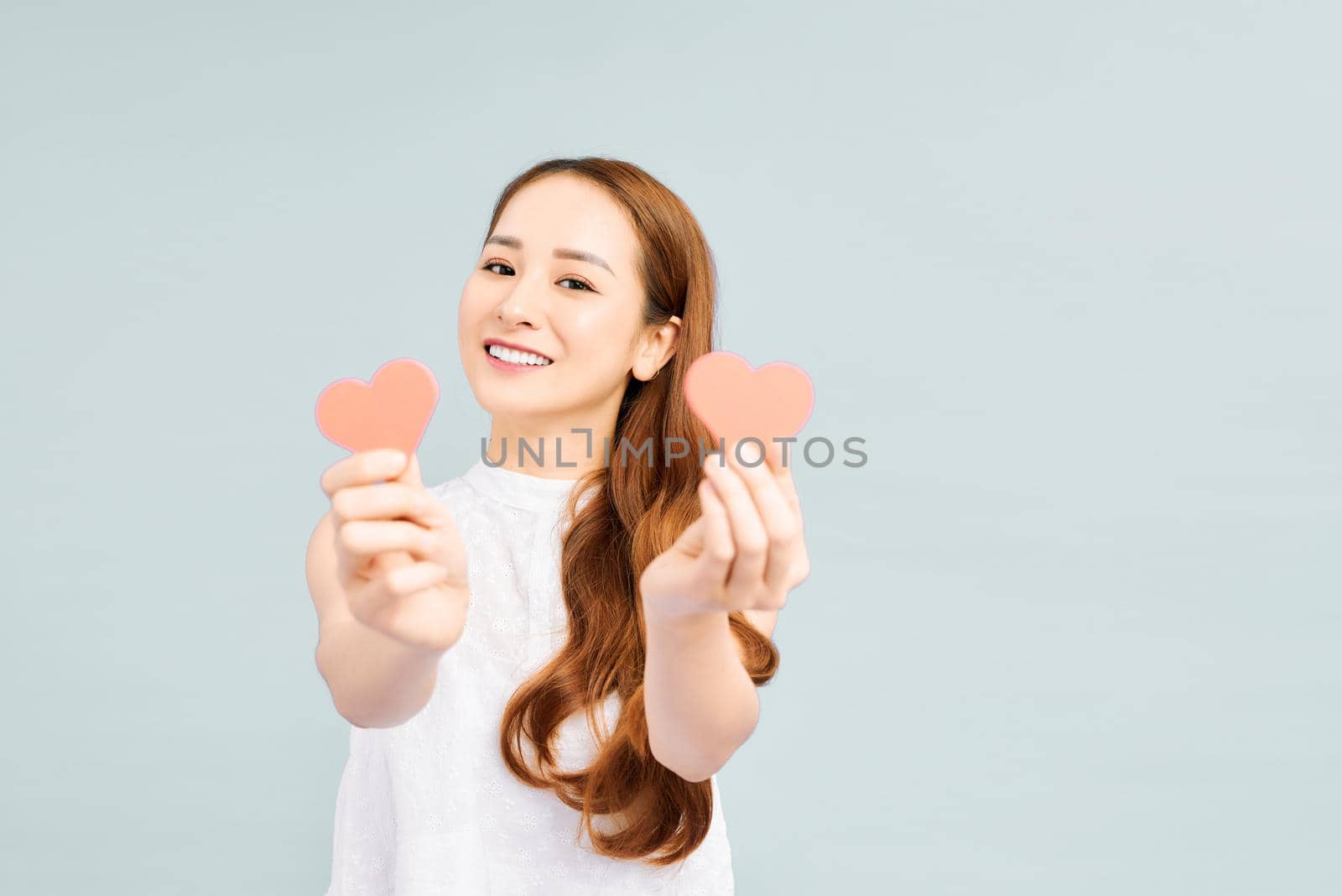 Portrait of charming lady holding papercard heart looking smiling 