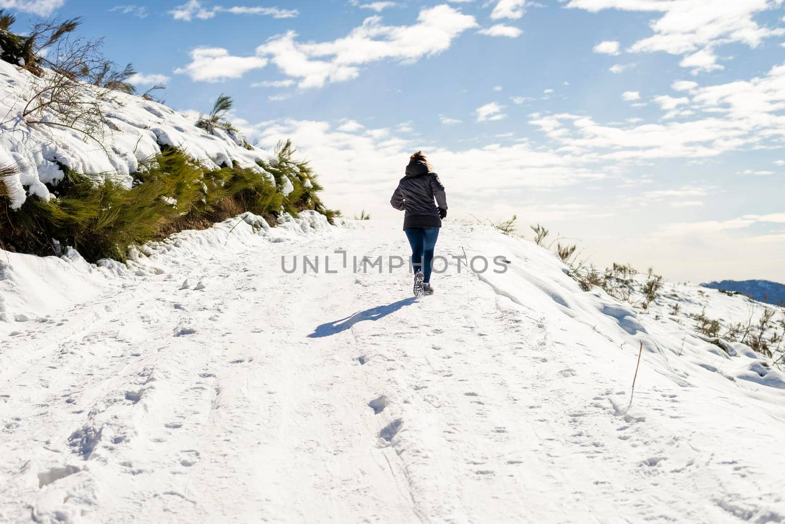 Young traveler woman jogging on snowed mountain by raferto1973