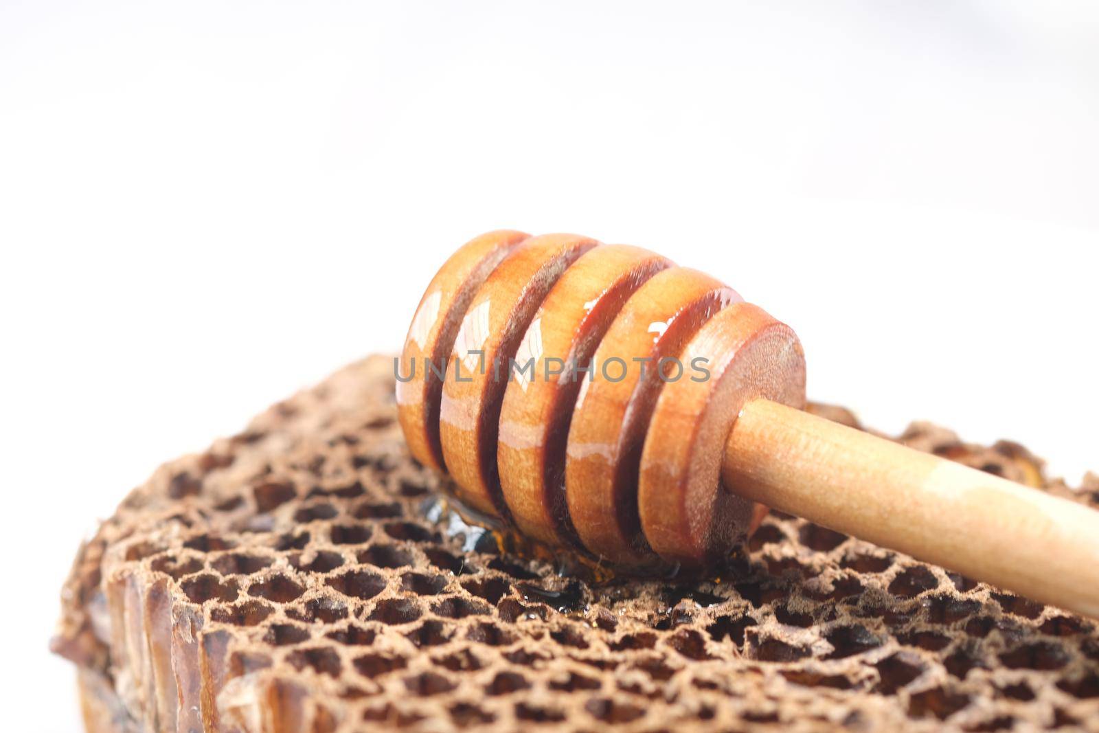 fresh honey with spoon and honey comb on white .