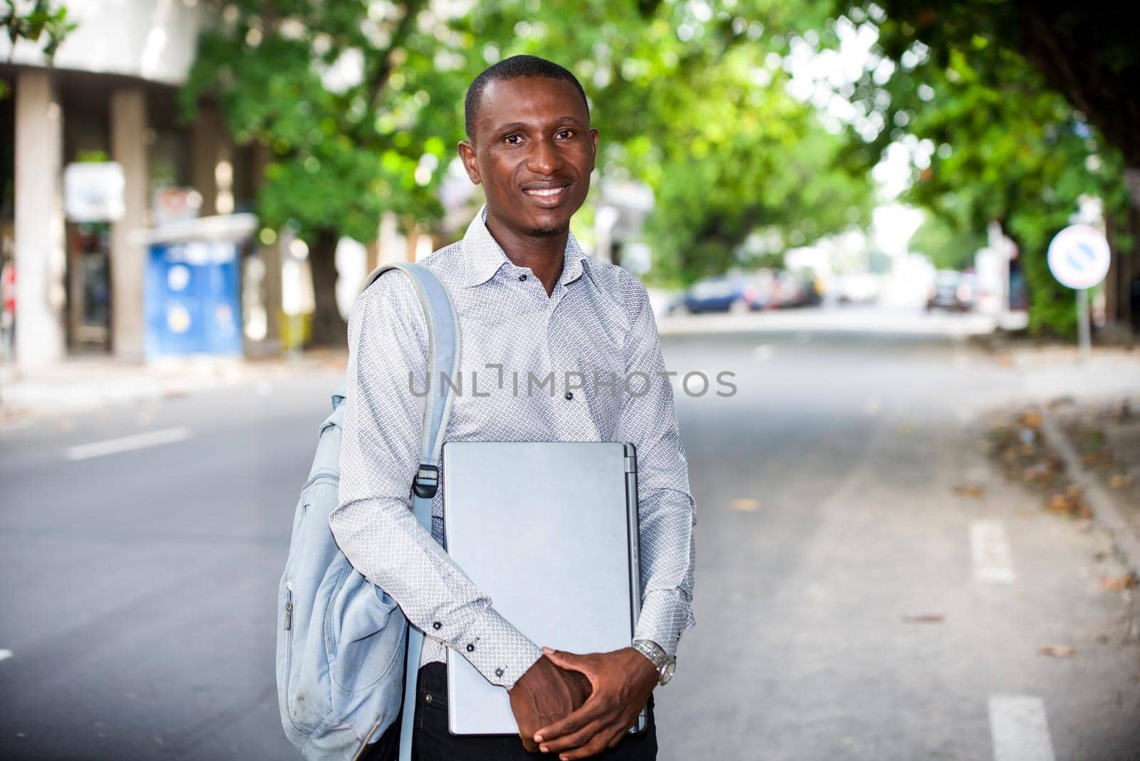 portrait of young man with laptop, smiling. by vystek