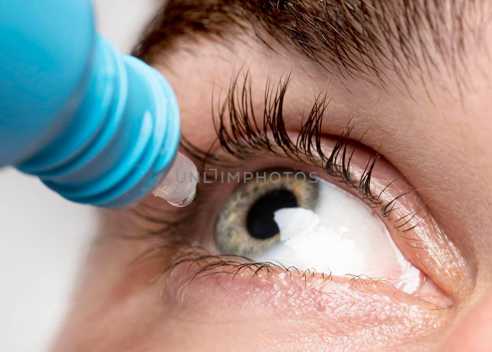 man using eye drops close up. Beautiful photo