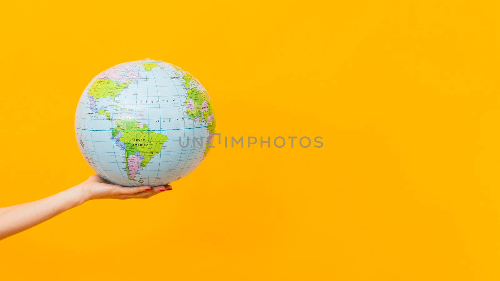 side view hand holding earth globe with copy space. High resolution photo