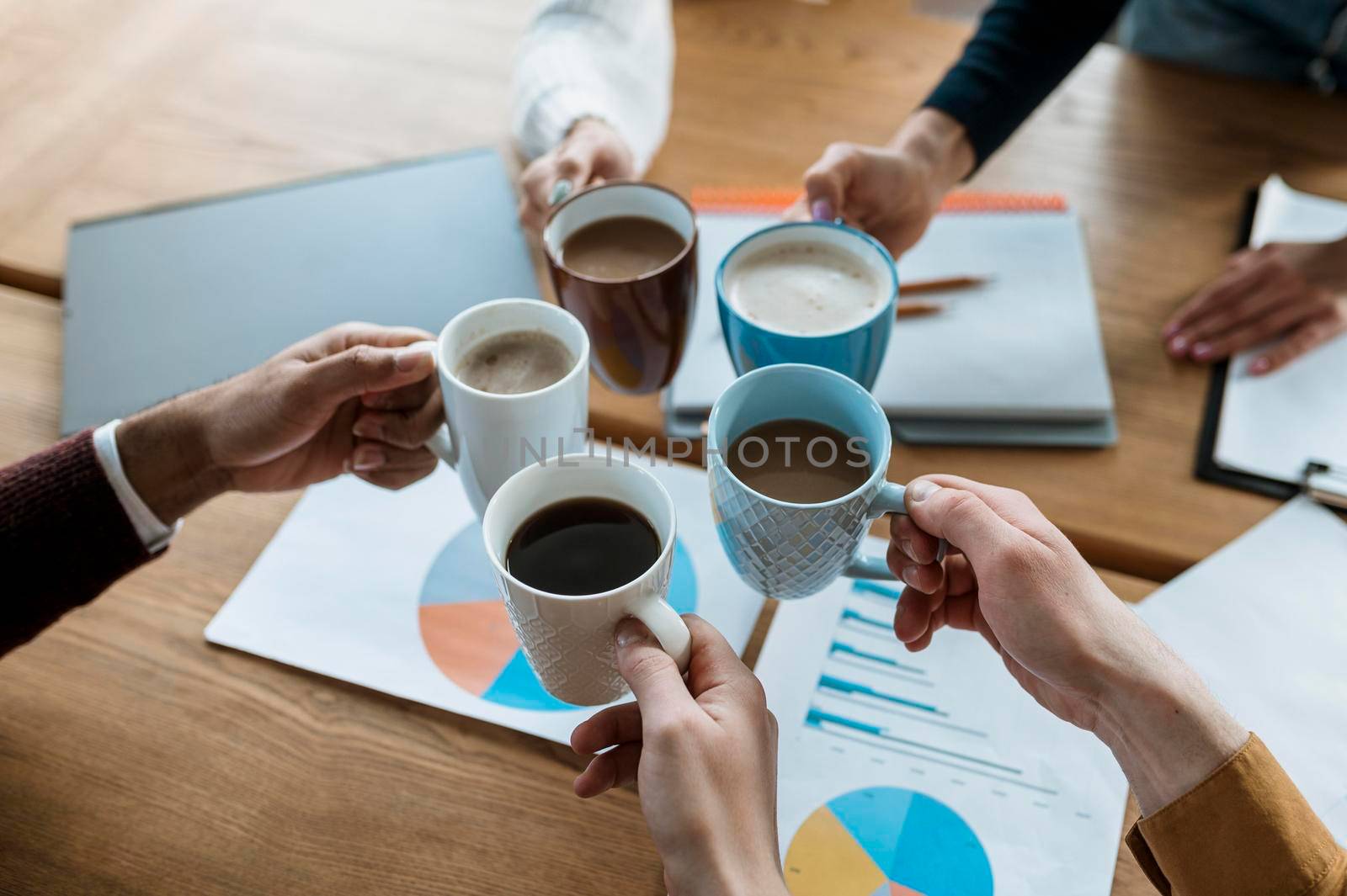 high angle people cheering with coffee mugs during office meeting. High quality photo by Zahard