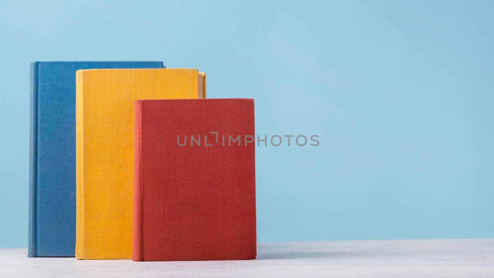 front view three colored books with copy space. High resolution photo
