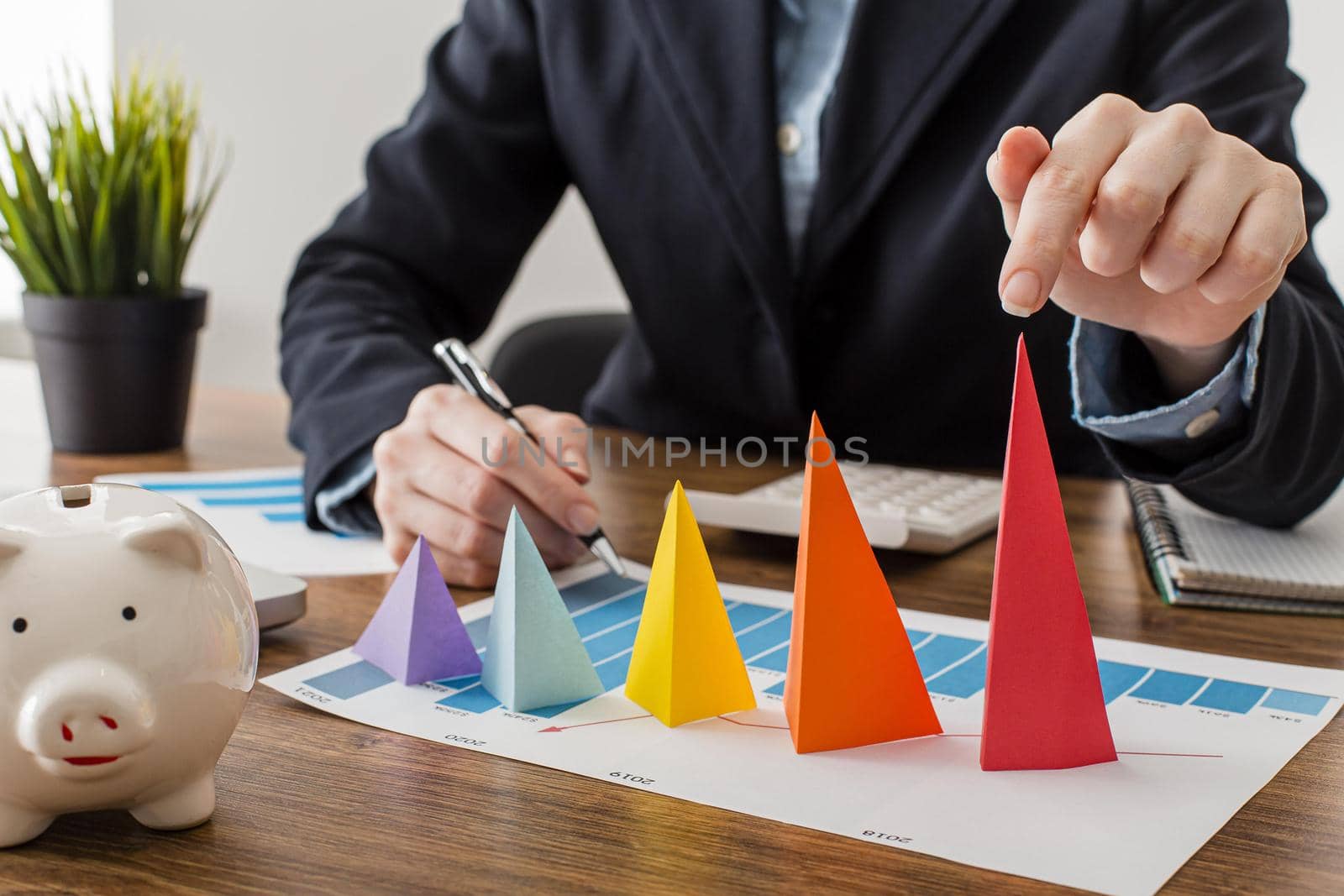 front view businessman with colorful cones representing growth. Resolution and high quality beautiful photo