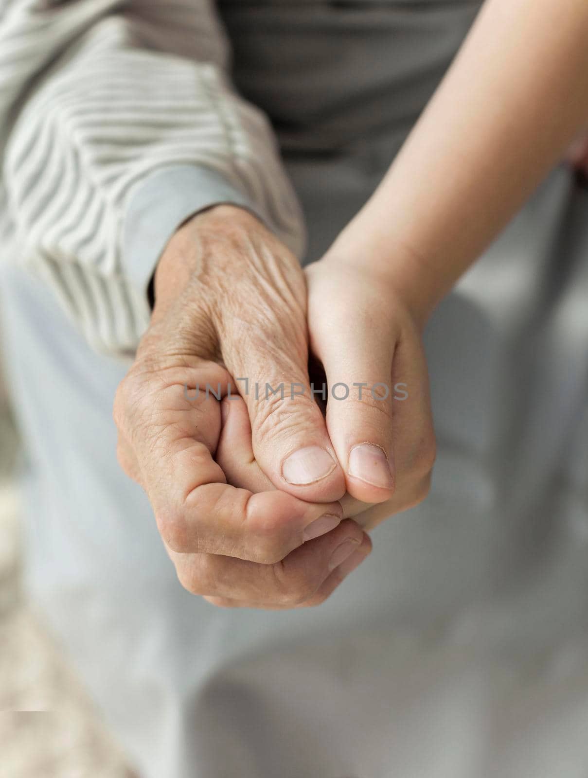 close up granddaughter holding grandmothers hand. Beautiful photo